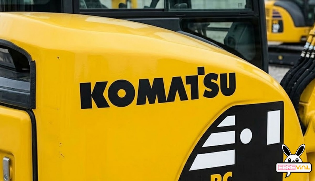 Pegatina logo Komatsu en vinilo de corte negro sin fondo sobre capó amarillo de excavadora